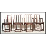 A set of four matching Chinese rail back dining chairs / elbow chairs, solid seat pads with turned