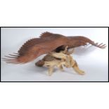 A large 20th century fantastic detailed carved sculpture of an eagle raised on naturalistic wooden