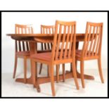A late 20th century G-Plan teak wood dining table and chairs.  The extending table raised on