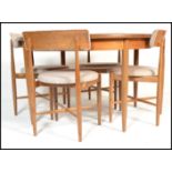 A set of 4 teak G-plan dining chairs designed by Koford Larsen. Raised on tapered turned legs with