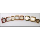 A group of eight vintage 20th century travel alarm clocks most in metamorphic cases. Includes