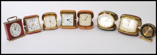 A group of eight vintage 20th century travel alarm clocks most in metamorphic cases. Includes