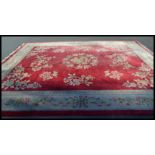 A 20th Century vintage floor rug / mat of large proportions on red ground, central panel with
