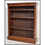 An Edwardian mahogany open window library bookcase being raised on a plinth base with shelves to