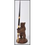 A vintage early 20th century Blackforest carved pen stand in the form of a bear raised on circular