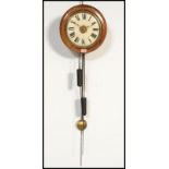 A Victorian mahogany and brass postmans clock. The circular dial with roman numeral chapter ring