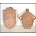 Two terracotta amphora urns, one having twin handles and some remains of paint decoration to body,