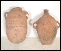 Two terracotta amphora urns, one having twin handles and some remains of paint decoration to body,