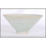 A believed antique Chinese Celadon glaze bowl of conical form raised on small circular foot.