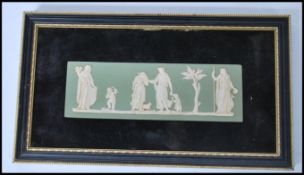 A framed Wedgwood jasper ware / cameo ware wall plaque, on a green ground having raised white