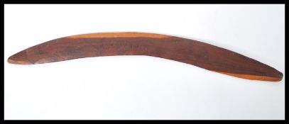 A 20th Century Australian hard carved wooden boomerang having unusual emu decoration. Measures