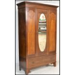 An Edwardian mahogany inlaid  single wardrobe being raised on a plinth drawer base with central
