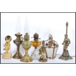 A collection of vintage lighting to include three oil lamps, two vintage cherub lamps, fish lamp,