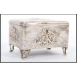 An early 20th century hallmarked silver jewellery casket box raised on scrolled feet having relief