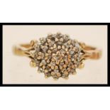 A hallmarked 9ct gold cluster ring having a round head set with a cluster of white stones, having