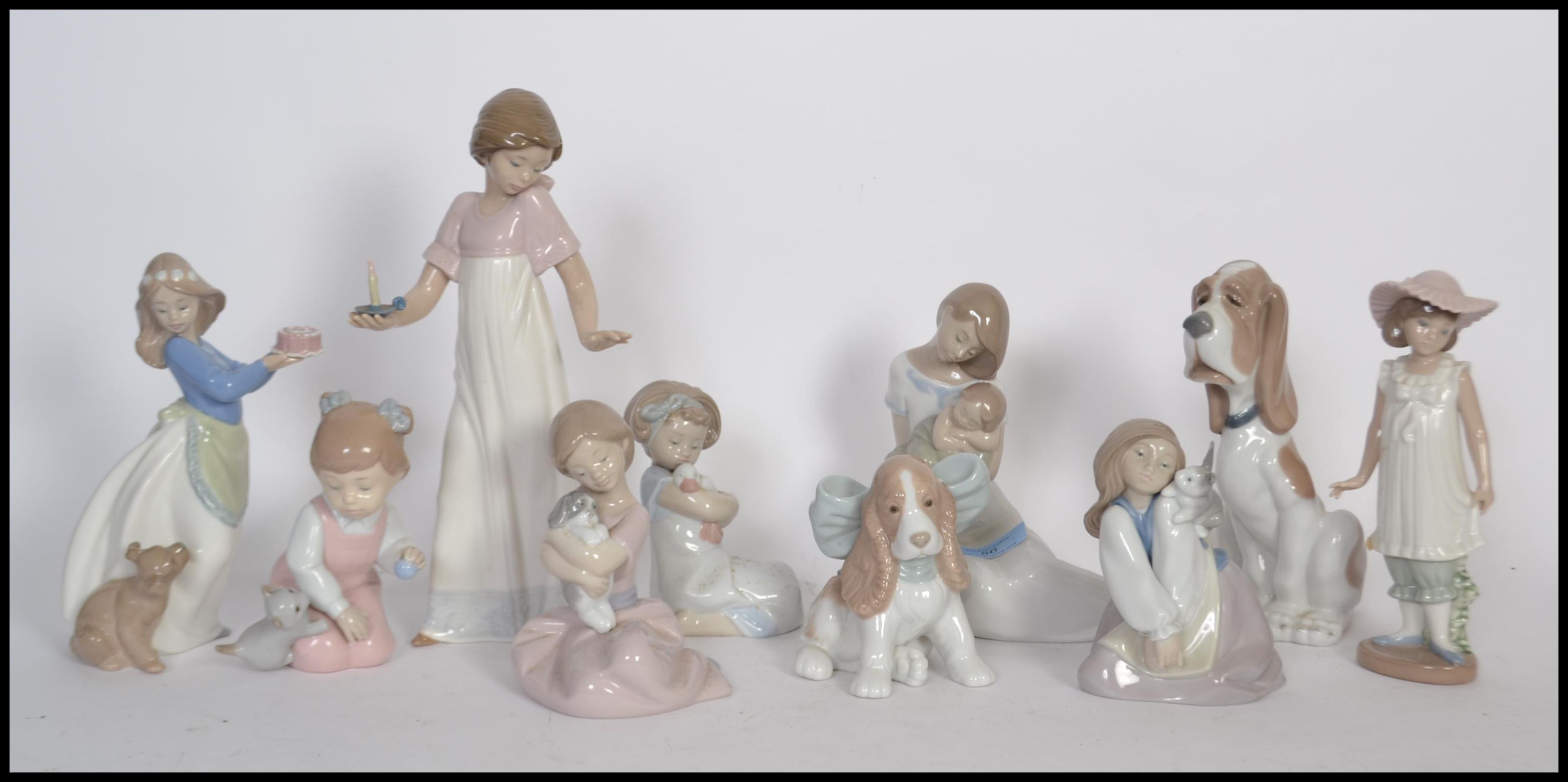 A collection of NAO ceramic figurines to include a mother and child figure, a girl holding a candle,