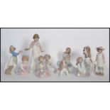 A collection of NAO ceramic figurines to include a mother and child figure, a girl holding a candle,