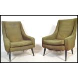 A  pair of retro 1960's armchairs in the manner of Greaves and Thomas, Raised on tapering ebonised