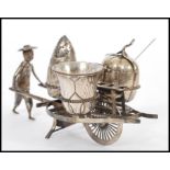 A 20th Century Chinese silver cruet set in the form of a man pushing a wheel barrow having three