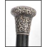 A 19th century Victorian walking stick cane having a tapering ebony shaft with scrolled and