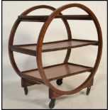 A 1930's Art Deco teak trolley of circular form with multiple tiers having faux coromandel tier