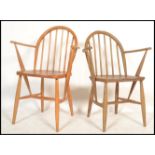 A near pair of Ercol light elm and beech  hoop back carver dining chairs, the chairs with solid seat