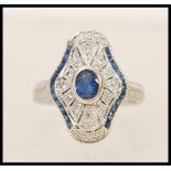 A 1920's 18ct white gold art deco panel ring set with a central oval cut sapphire in a shaped