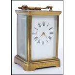 An early 20th Century brass bound carriage clock having roman numerals to the chapter ring and