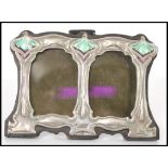 A Liberty / Art Nouveau style double picture frame with sterling silver decoration to the front with