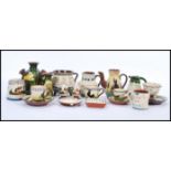 A selection of Torquay Mottoware to include creamer jugs, stem vases, plates condiments etc. All