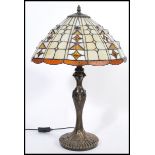 A 20th Century twin bulb Tiffany inspired table lamp, the cast base of Art Nouveau taste having a