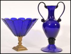 Two blue glass wares to include a large Bristol blue acid signed twin handled vase raised on