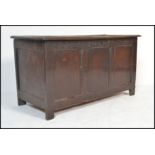 An 18th century oak coffer, the hinged plank top with steel strap hinges over single panel sides and