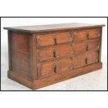 A Jacobean revival geometric fronted low ' end of bed' oak chest of drawers. Raised on a plinth base