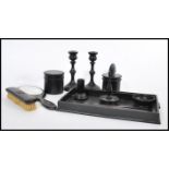 An early 20th Century ebony dressing table set, having a gallery tray, candlesticks, ring stand,