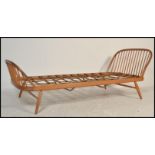A mid century Ercol blonde beech and elm wood single bed / studio day bed / sofa settee. Raised on
