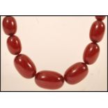 A vintage 20th century cherry amber bakelite necklace chain having 55 graduating beads with yellow