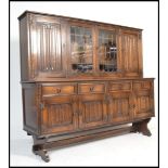 A Jaycee medium oak linen fold drawer dresser with lead glazed display cupboard flanked by carved