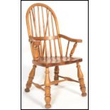 A 20th Century Victorian style country pine windsor arm elbow chair with railed spindle and hoop
