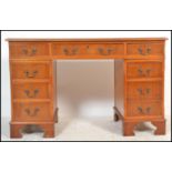 A contemporary mahogany 20th Century twin pedestal desk, having an arrangement of nine drawers