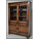 A Jaycee oak china - bookcase display cabinet having leaded glass doors with further cupboard with