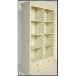 A large contemporary painted bookcase cabinet, possibly Laura Ashley or Multiyork. Raised on