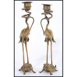 A pair of 19th century bronze candlesticks in the form of Chinese cranes stood on turtles with snake
