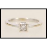 An 18ct white gold solitaire ring set with a square cut with stone to the head. Hallmarked London.