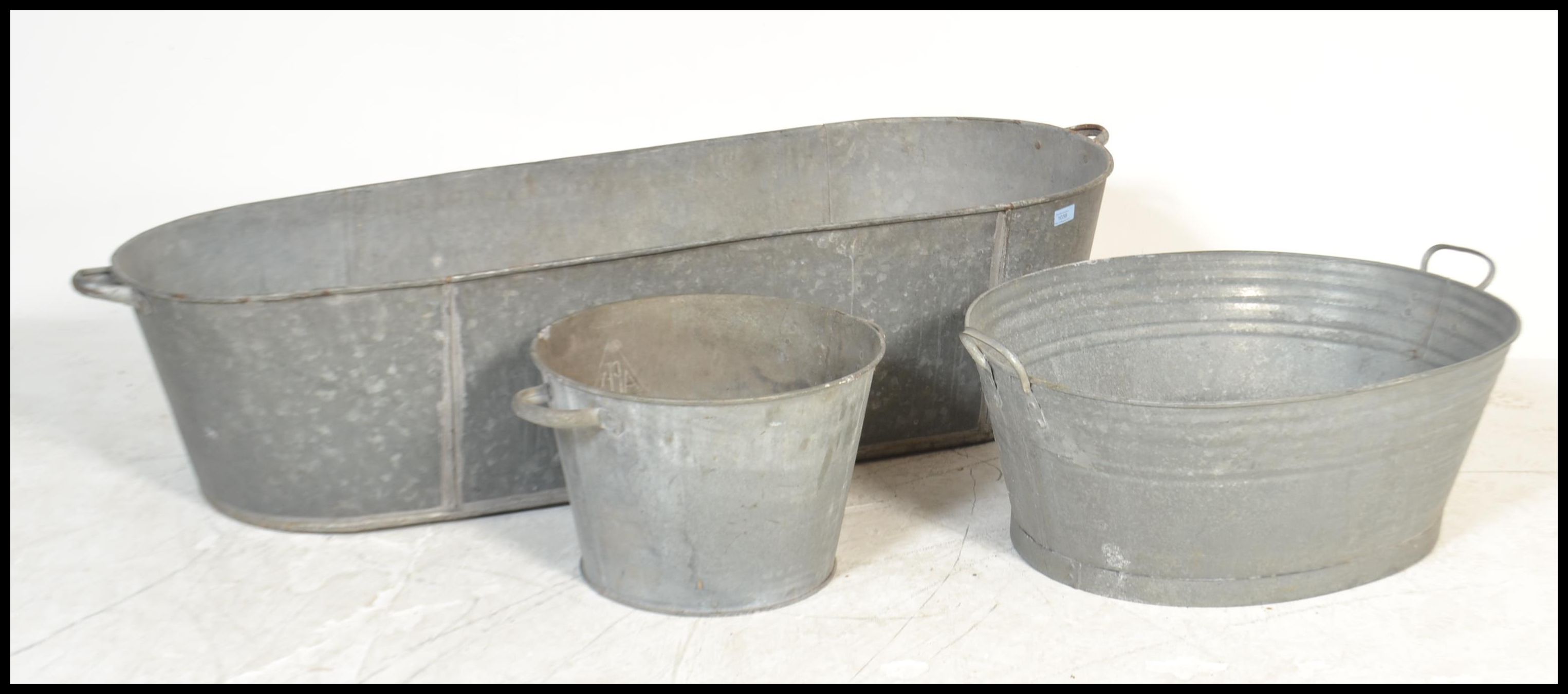A vintage 20th Century galvanised coffin shaped tin bath of large proportions together with