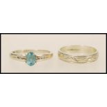 A stamped 375 9ct white gold ring set with an oval cut blue topaz stone with channel set white