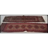Two early 20th century Persian Middle Eastern carpet runner rugs, both having red ground with
