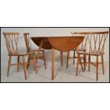 A vintage retro Ercol drop leaf dining table along with a set of four vintage mid 20th Century Ercol