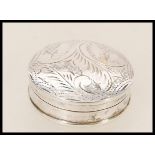 A stamped 925 silver pill box of round form having foliate engraving to the domed lid. Total