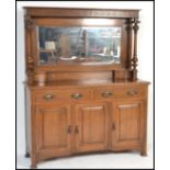 A Victorian oak Arts & Crafts mirror back sideboard having short drawers over cupboard with good